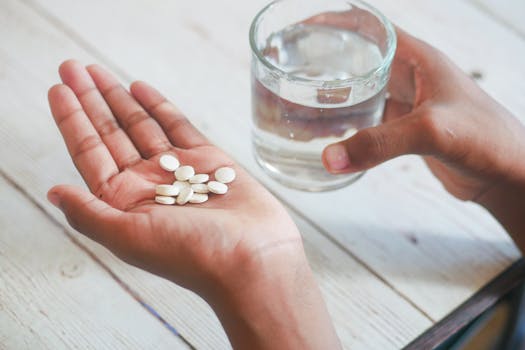 a person taking supplements with a glass of water